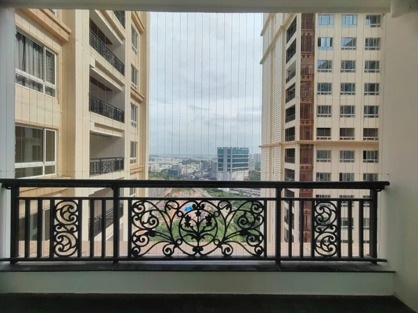 Vertical cables above an ornamental balcony railing.