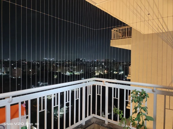 A night view of vertical cables around a balcony corner.
